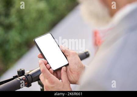 Man holding smartphone mockup screen using electric bike rental mobile app. Stock Photo