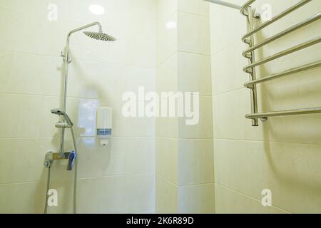 Bright bathroom with shower, shower head, light tile Stock Photo