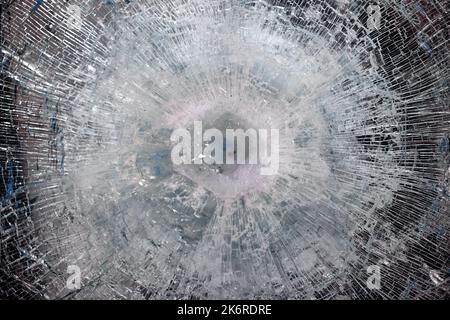 Bulletproof glass after test. bulletproof glass with cracks and a crater from a bullet hit. Testing of armored glass Stock Photo