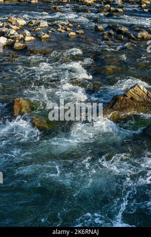 Flow, for a stormy river among the rocks in the autumn park on a warm day. Beautiful landscape of water surface Stock Photo