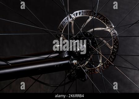 Close-up shot of a generic mountain bike disc brake rotor that is mounted on a bicycle. Stock Photo