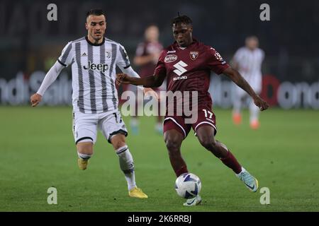 Turin, Italy, 15th October 2022. Filip Kostic of Juventus closes in on Wilfried Singo of Torino FC as he lays the ball off to his goalkeeper during the Serie A match at Stadio Grande Torino, Turin. Picture credit should read: Jonathan Moscrop / Sportimage Stock Photo