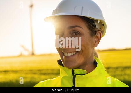 happy female engineer with safety helmet smiling to camera. New Energy concept image Stock Photo