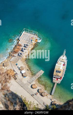 Oludeniz, Mugla, Turkey – August 22, 2021. Mediterranean coastline and tourist boat in Kidrak neighbourhood of Oludeniz beach resort in the Fethiye di Stock Photo
