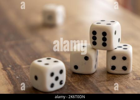 Plastic dice stacked on a wooden surface. Board game concept. Stock Photo