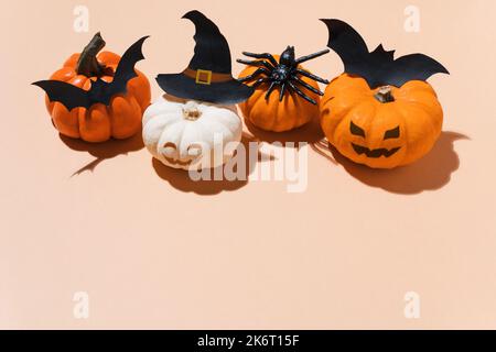 Halloween party decoration - pumpkins with bats, spiders and witch hat accessories. Pumpkin Halloween decoration idea. Copy space, blogs, promotion, s Stock Photo