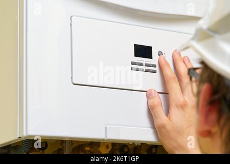 Setting up and servicing by a service department. Adjustment of gas boiler at domestic home. Stock Photo