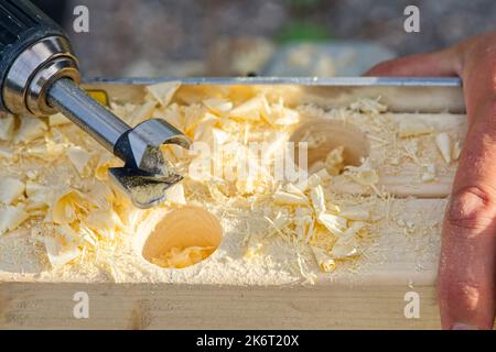 Carpenter drilling holes in the wood beam. wooden frame domestic house building Stock Photo