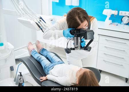 Dentist taking photos of little patient teeth during consultation Stock Photo