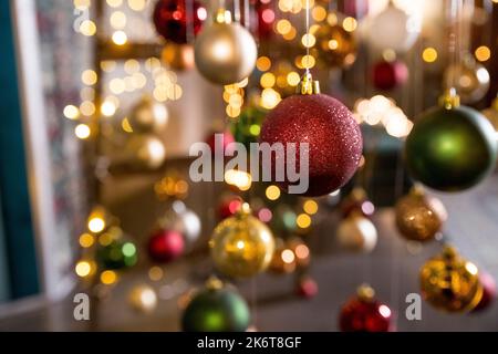 New Year Tree Art Installation Made with String Lights and Christmas Balls Hanging on Threads on blurred Background.christmas ornaments hanging on the Stock Photo