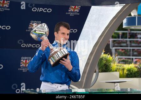 Ascot, Berkshire, UK. 15th October, 2022. William Buick realised a long-held ambition at Ascot today as he was crowned Champion Jockey for the first time. Racing legend Willie Carson presented him with the trophy. The 34-year-old has dominated the championship from the outset and begins the final day of the season on 157 winners, 67 clear of his closest challengers Hollie Doyle and Tom Marquand. Credit: Maureen McLean/Alamy Live News Stock Photo