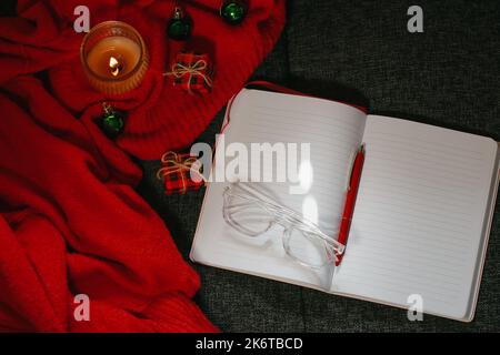 Christmas composition with notebook, pen, glasses, candle and decor Stock Photo