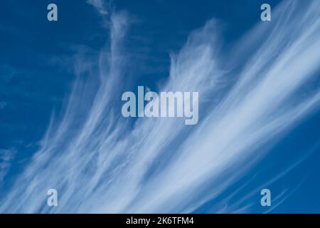 Wispy white clouds against a bright blue sky Stock Photo
