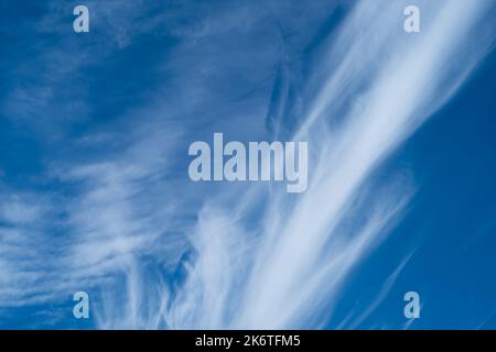 Wispy white clouds against a bright blue sky Stock Photo