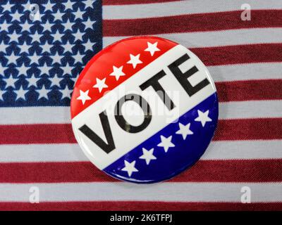 Close up of a vote campaign button on an American flag Stock Photo