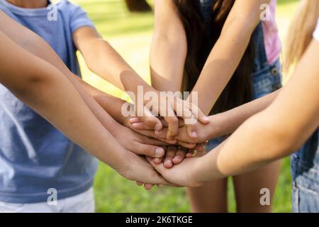 Boys girls bringing their hands together Stock Photo