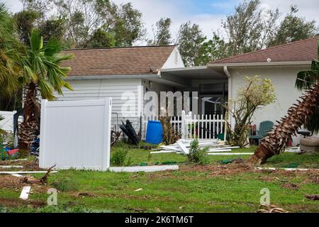 Fallen down big tree caused damage of yard fence after hurricane Ian in Florida. Consequences of natural disaster. Stock Photo