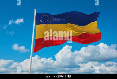 flag of Daco-Romance peoples Serbian Romanians at cloudy sky background, panoramic view. flag representing ethnic group or culture, regional authoriti Stock Photo