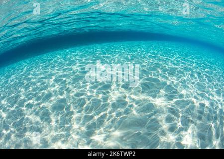 Bright sunlight reflects off of white sand in the clear, warm seas of the tropical Pacific. Stock Photo