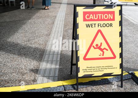 Sign showing warning of caution wet floor on the pathway. Stock Photo