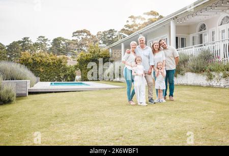 Happy cheerful family standing together outside in the garden. Family relaxing outdoors with their children. Portrait of a mature and young family Stock Photo