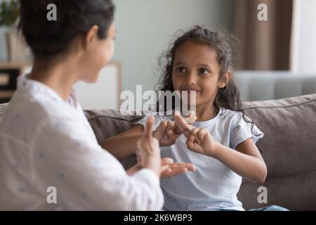 Deaf Indian girl and mother communicating using sign language Stock Photo