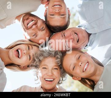 Being a family means you are a part of something very wonderful. a multi-generational family standing together in a huddle. Stock Photo