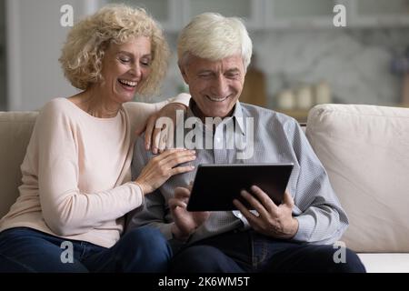 Retired couple spends free time using digital tablet Stock Photo