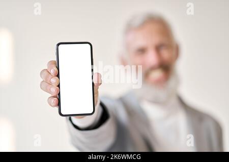 Business man wearing suit holding smartphone with white mock up screen isolated. Stock Photo