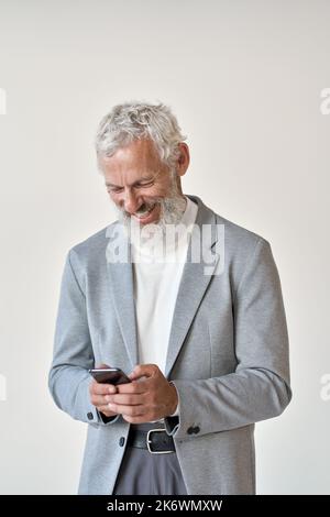 Happy old senior businessman using smartphone standing isolated on white. Stock Photo