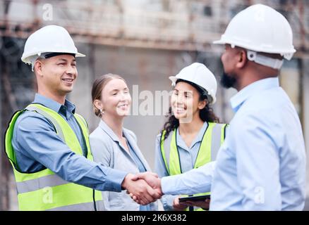 Great partnerships start with a smile. two architects shaking hands at a building site. Stock Photo