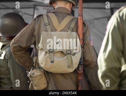 US Army United States Soldier World War Two in uniform with rifle and backpack wearing helmet. Stock Photo
