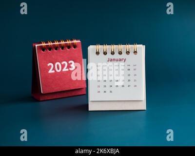 January 2023 calendar desk for the organizer to plan and reminder on blue background. White small square table calendar with the first month near the Stock Photo