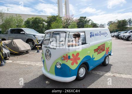 Atibaia - Brazil, October 7, 2022: Boy in sunglasses posing in a miniature van replica of the Scooby Doo mystery machine and the gang, Shaggy, Fred, D Stock Photo