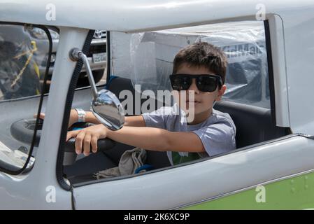 Atibaia - Brazil, October 7, 2022: Boy in sunglasses posing in a miniature van replica of the Scooby Doo mystery machine and the gang, Shaggy, Fred, D Stock Photo