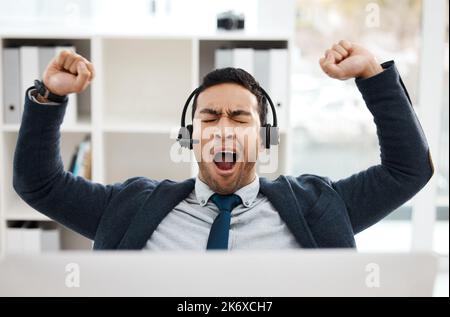 Sometimes all you need is a good yawn. a young male call center agent yawning while working in an office. Stock Photo