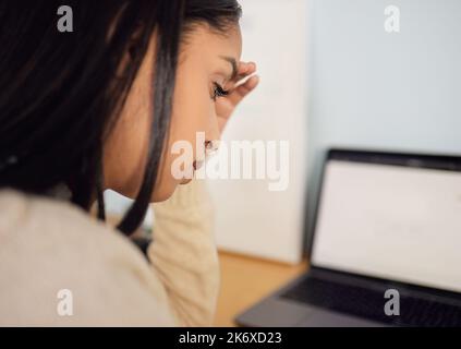 I dont know how Im going to get through. a beautiful young woman looking stressed while sitting at home. Stock Photo