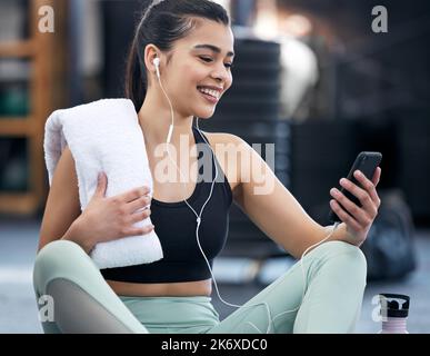 After the cool down comes the selfie. a fit young woman using a smartphone in a gym. Stock Photo