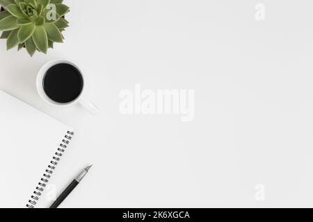 Workspace accessories, coffee and a succulent plant on a white table.  Flat lay with blank copy space. Stock Photo