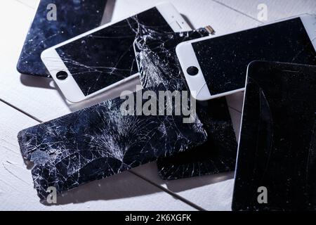 Mobile tablet device with a broken badly cracked shattered glass on the touch screen. Smart hardware part replacement, fixing concept Stock Photo