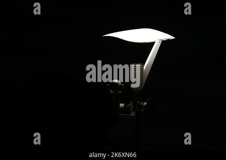 Light Pole with Security Camera equipment over black background. Isolated Stock Photo