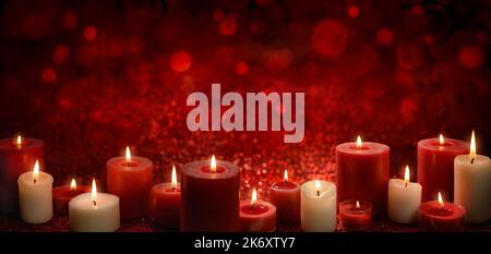 Burning candles as a border on a red festive background with glittering bokeh lights, ideal for Christmas or religious events, wide format with copy-s Stock Photo