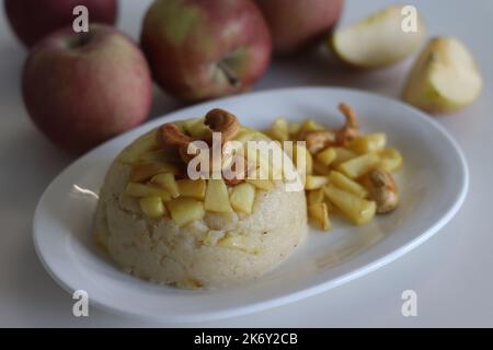 Apple Sheera. Indian pudding made of semolina flour, ghee, milk, dates and dry fruits served with caramelised apple. Classic Indian sweet shot on whit Stock Photo