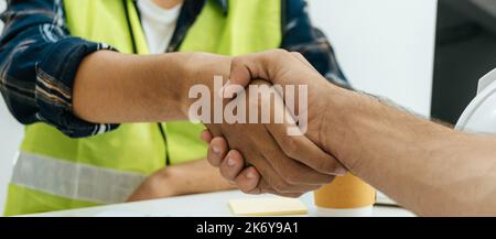 Partnership. cropped view construction worker hand shake together after new project plan in meeting room at construction site, partner, industrial, co Stock Photo