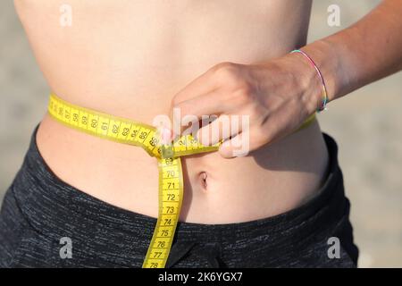 https://l450v.alamy.com/450v/2k6ygx7/skinny-girl-measures-your-waist-with-a-yellow-tape-measure-and-measures-in-centimeters-2k6ygx7.jpg