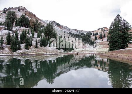 Volcanic lake in the snowy mountains. Ridge lakes in Lassen Volcanic National Park in California. Reflective mountain lake Stock Photo