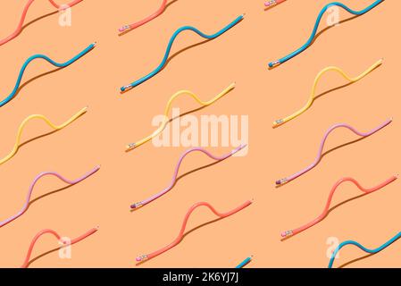 Pastel multi colored pencils in pattern on brown background. Minimal concept. Isometric layout. Wallpaper Stock Photo