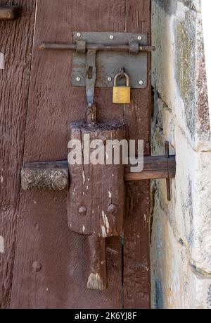 close-up of a vintage hand-made wooden door latch, bolt and padlock Stock Photo