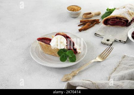 pieces of Cherry strudel with fresh mint on the plate on light bakground, copy space Stock Photo