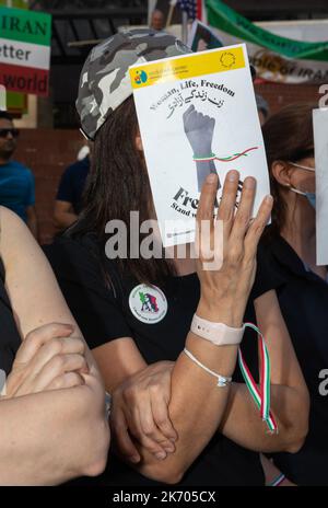 A young woman with a bandage on her arm in the colors of the Iranian flag holds a placard with the inscription 'Women Life Freedom' during the demonstration. In Downtown Portland hundreds of people gathered to bring awareness to what they say is a huge women's rights issue in Iran. They came together to call attention to the death of 22-year-old Mahsa Amini, who died in Iran last month after police arrested her for improperly wearing a hijab, a traditional head scarf worn by some Muslim women. (Photo by Mykhaylo Palinchak/SOPA Images/Sipa USA) Stock Photo